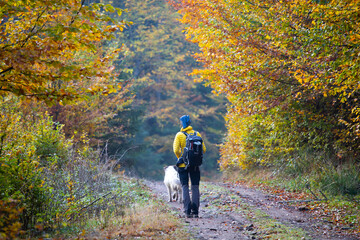 Woman trekking in high autumn mountains with her dog