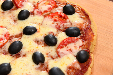homemade pizza, vegetarian food, baked vegetables and cheese, tomatoes and olives, delicious food on a wooden background