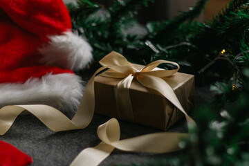 Christmas gift with Santa Claus hat and Christmas decorations on grey background with Christmas lights