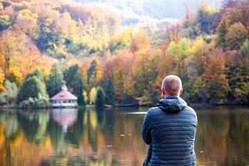 Fototapeta premium A man contemplates a lake while sitting alone.