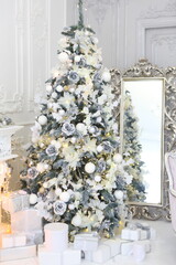 Celebratory New Year tree decorated with beautiful fur-tree toys and Christmas gifts in gift packages and celebratory boxes