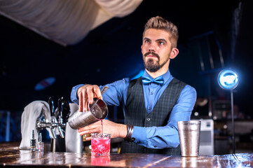 Bartender concocts a cocktail in the public house