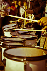 Fototapeta na wymiar A set of drums and hands with drumsticks playing outdoors.