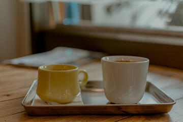 Hot coffee and tea on wooden table in cafe.