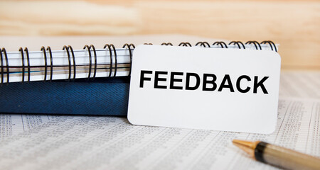 ON the card text FEEDBACK, next to textbooks, pen, ochty.