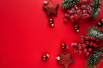 Christmas red decorations, fir tree branches on red background