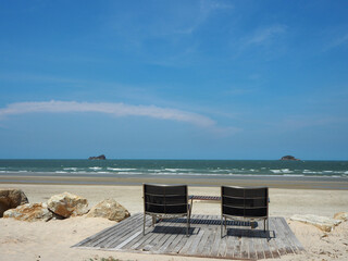 Two cozy seats for a couple on the beach on a beautiful day — a perfect image for promoting relaxation and resort-style vacations.