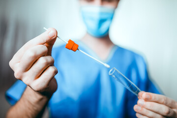 Medico o infermiere fa il test del tampone salivare nella provetta
