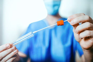 Medico o infermiere fa il test del tampone salivare nella provetta