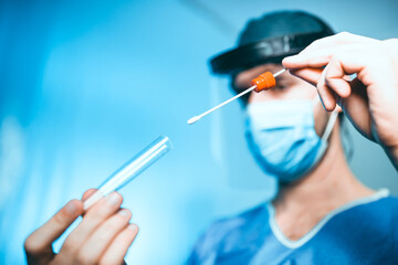 Medico o infermiere fa il test del tampone salivare nella provetta