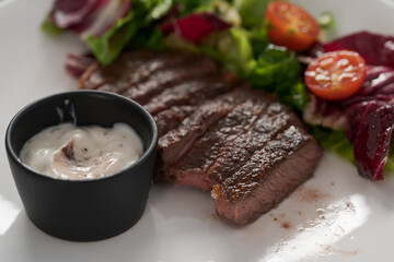 ribeye steak with garlic sauce and fresh salad closeup