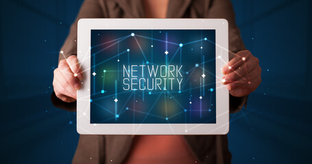 Young business person working on tablet and shows the digital sign: NETWORK SECURITY