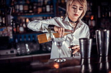 Professional woman tapster demonstrates his professional skills in pub