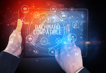 Close-up of a tablet with BACKWARD COMPATIBLE inscription, innovative technology concept