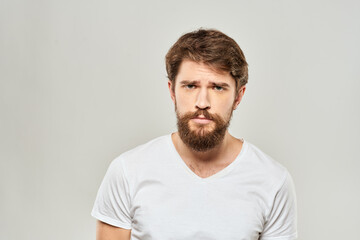 Fototapeta premium man in white t-shirt gesturing with his hands studio dissatisfaction lifestyle light background