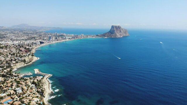Beautiful super wide-angle aerial view of Calpe, Calp, Spain with harbor and skyline, Penon de Ifach mountain, beach and scenery beyond the city, seen from Mirador Monte Toix mountain viewpoint