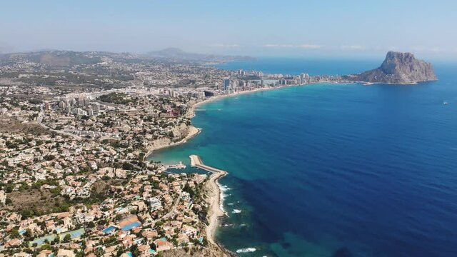 Beautiful super wide-angle aerial view of Calpe, Calp, Spain with harbor and skyline, Penon de Ifach mountain, beach and scenery beyond the city, seen from Mirador Monte Toix mountain viewpoint