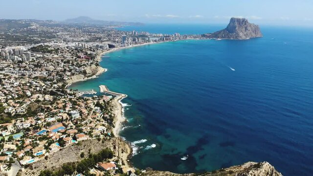 Beautiful super wide-angle aerial view of Calpe, Calp, Spain with harbor and skyline, Penon de Ifach mountain, beach and scenery beyond the city, seen from Mirador Monte Toix mountain viewpoint