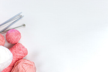 Balls of pink yarn on white background. Female needlework and hobby concept. Flat lay, top view. Banner.