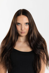 Naklejka premium Portrait of a teenage girl with dark and long hair and beautiful makeup. Tanned European female beauty.