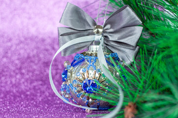 Beautiful and very shiny bead. Toy for the Christmas tree. Christmas balloon on a purple background. New year greetings, postcards, calendar.