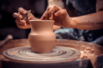 Potter's wheel and the hands of an artisan. Close-up.