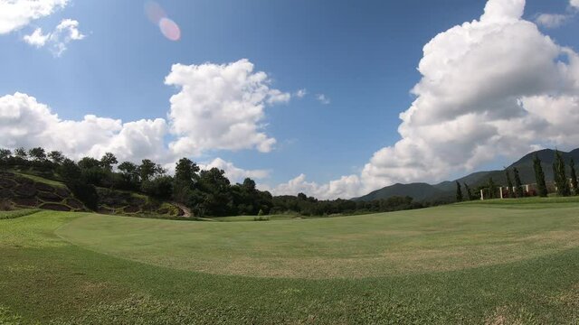 time lapse landscape moving clouds and golf course