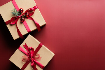 Gift boxes with red ribbon bow on marsala red background with copy space. Christmas presents, gift boxes, surprises concept. Flat lay, top view.