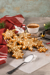 Gingerbread cookies with icing on countertop with festive lights. Christmas cookies snow flakes decorated with sugar frosting. Christmas holiday tradition and advent