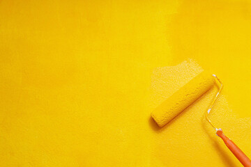 Roller Brush Painting, Worker painting on surface wall  Painting apartment, renovating with yellow color  paint. Leave empty copy space to write descriptive text beside.