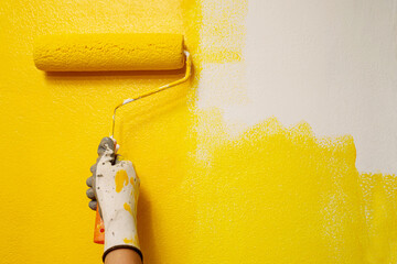 Roller Brush Painting, Worker painting on surface wall  Painting apartment, renovating with yellow color  paint. Leave empty copy space white to write descriptive text beside. - obrazy, fototapety, plakaty