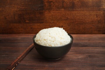 Steamed white rice cooked in a bowl on a wooden table.