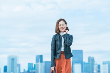 Fototapeta na wymiar 屋外で笑顔を見せるオフィスカジュアルスタイルの女性