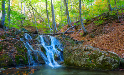 small waterfall on autumn mountain river