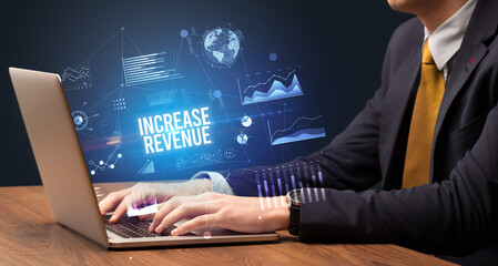 Businessman working on laptop with INCREASE REVENUE inscription, new business concept