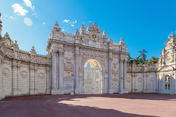 Obraz premium The luxurious North Gate of Dolmabahce Palace. Beautiful white stone gates with columns are decorated with carvings, turrets and gilding