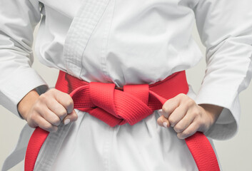 hands grabbing red karate belt © Irene