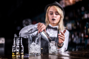 Sweet barmaid formulates a cocktail  