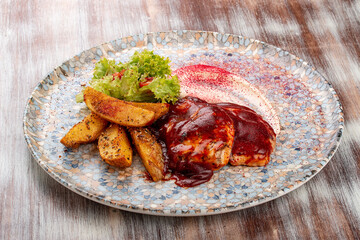 Grilled chicken fillet in barbecue sauce with baked potatoes and garlic sauce