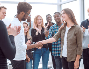 group of happy young people congratulating their colleague