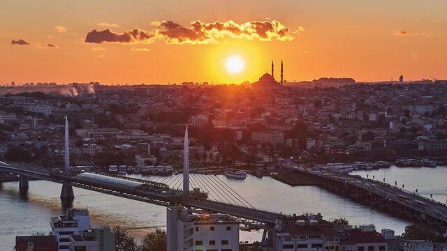 Sun is setting down behind Fatih Mosque. 4K time lapse panorama clip with Halic metro bridge. Taken from Galata Tower, Istanbul, Turkey
