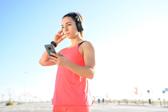 sporty woman listening to music with mobile