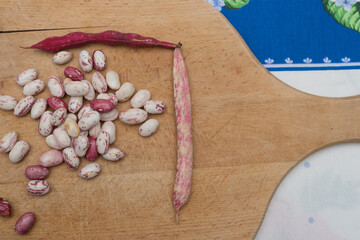 Borlotti beans peeled on wooden cutting board.