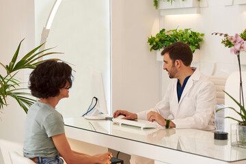 Doctor with a patient at the reception of the dental clinic.