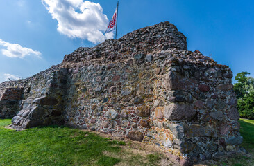 Fototapety  Ruiny zamku weneckiego na polu oświetlonym słońcem i błękitnym niebem w Polsce