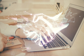 Handshake hologram drawing with businessman working on computer on background. Double exposure.