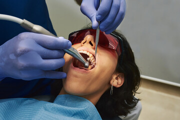 Dentist cleaning a patient's teeth.