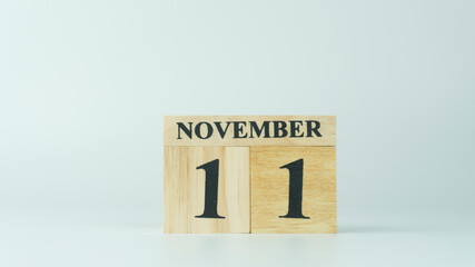 Wooden letters write the word November and the numbers 11 on white background with copy space. 11.11 single day sale concept