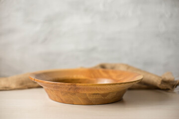 Wooden plate on a white table. National dishes. Crockery made from natural materials. Wood texture