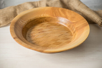 Wooden plate on a white table. National dishes. Crockery made from natural materials. Wood texture